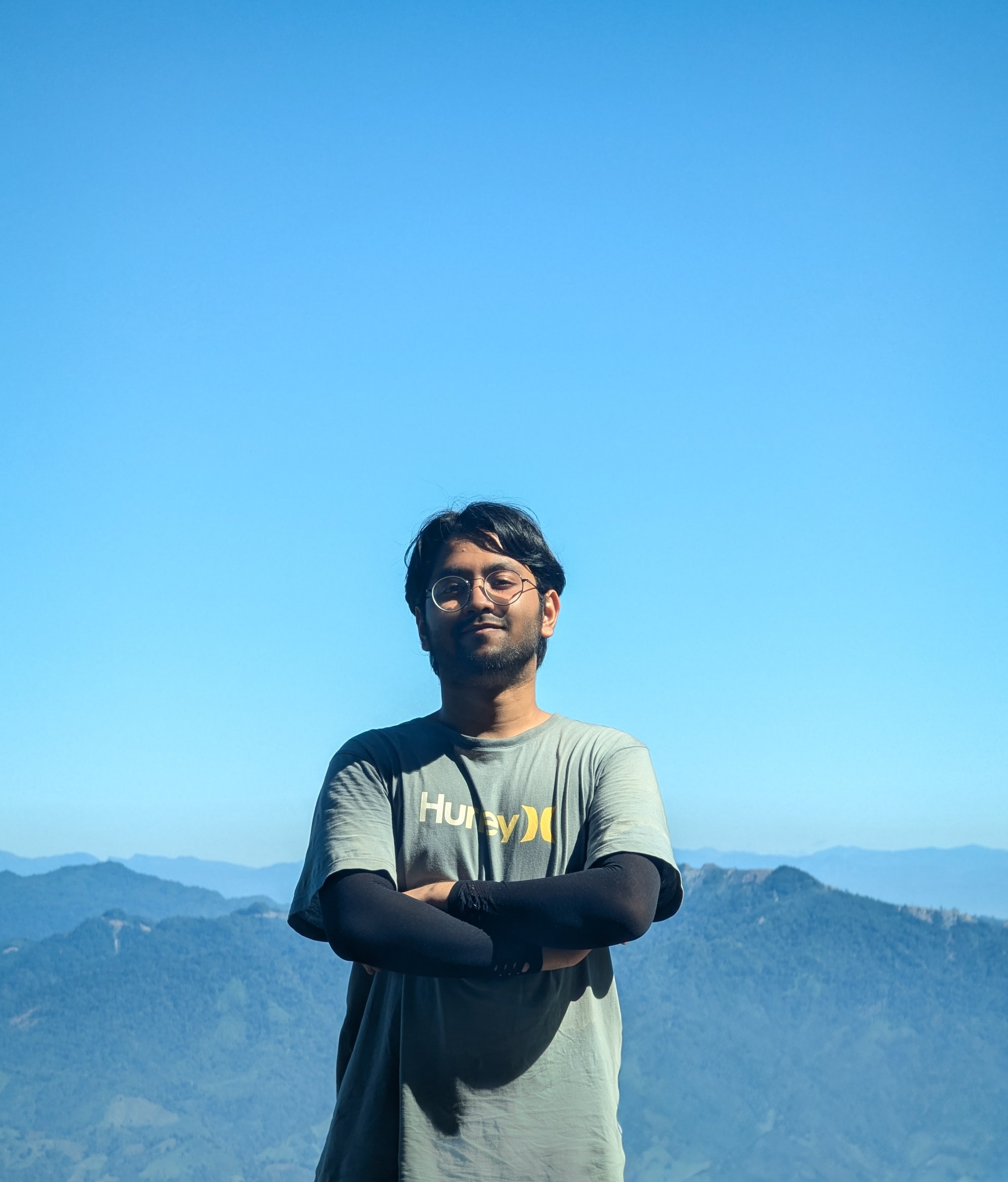 Afham Adian standing against a mountain landscape